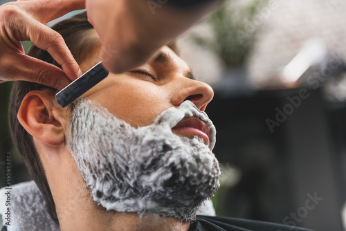 Barber shaving stubble of client