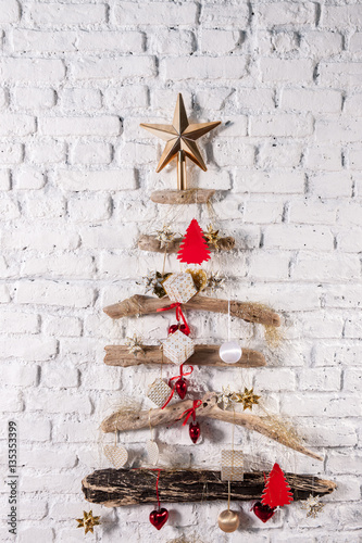 christmas tree with colourful ornaments over white brick wall decor photo
