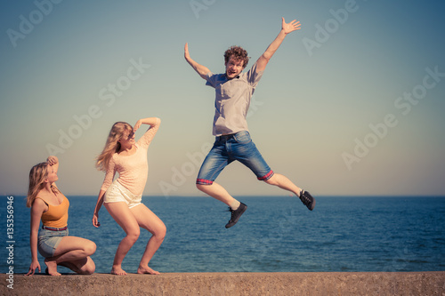 Group of friends boy two girls relaxing outdoor