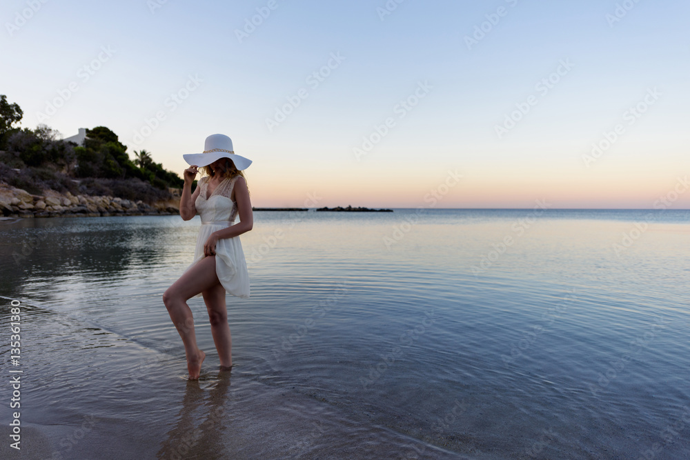 Woman walking down the beach at sunset. Beautiful Sunset sea view in Cyprus island Woman walking down the beach at sunset. Beautiful Sunset sea view in Cyprus island