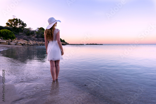 Woman walking down the beach at sunset. Beautiful Sunset sea view in Cyprus i...