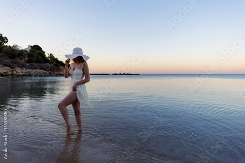 Woman walking down the beach at sunset. Beautiful Sunset sea view in Cyprus i...