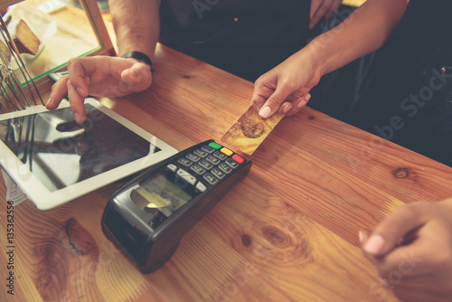 Quadro su tela Male and female paying bill in cafe
