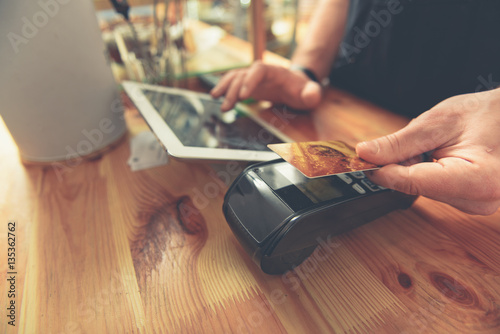 Foto Barista taking credit card to do payment for visitor