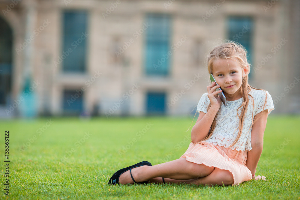Adorable toddler girl with smart phone in Paris during summer vacation Adorable toddler girl with smart phone in Paris during summer vacation