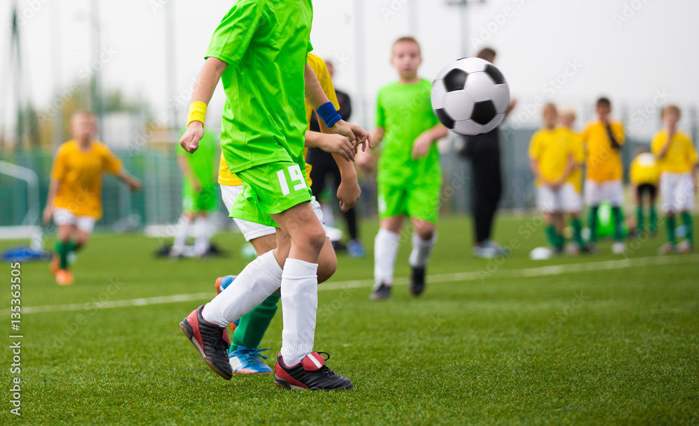 Children kicking soccer ball. Boys play football match Children kicking soccer ball. Boys play football match