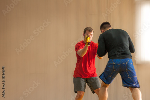 Two MMA fighters facing each other on the mat
