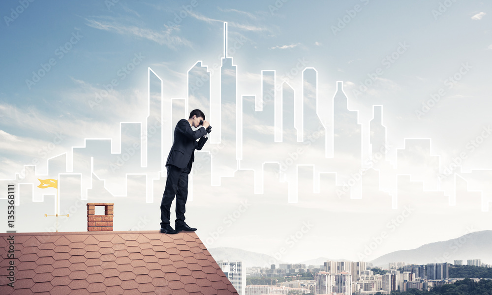 Businessman standing on roof and looking in binoculars. Mixed me