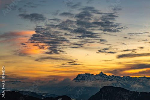 Vibrant orange sunset over snowy mountains