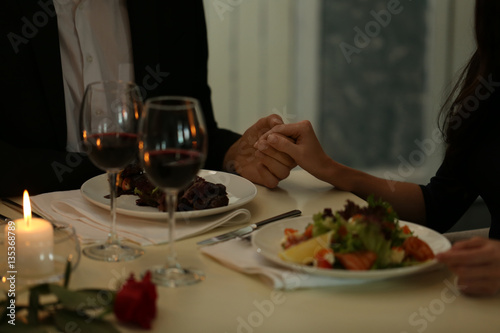 Couple holding their hands in restaurant