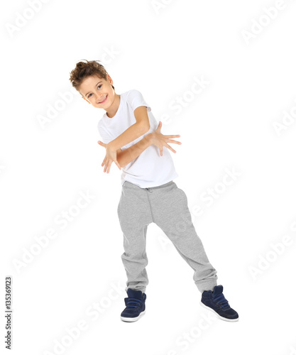 Cute boy dancing on white b...