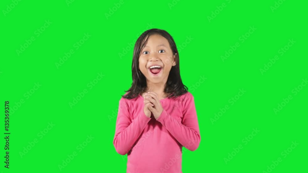 Cute little girl standing in the studio looks shocked and surprised, shot with green background Cute little girl standing in the studio looks shocked and surprised, shot with green background