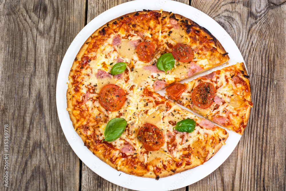 Pizza with ham, cheese, tomatoes and basil Pizza with ham, cheese, tomatoes and basil