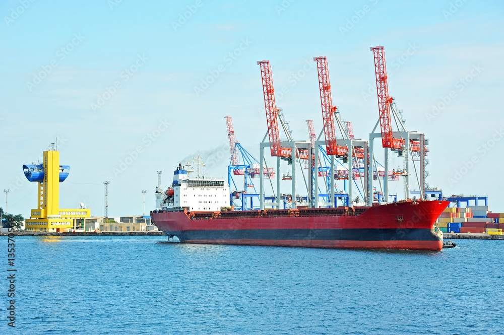 Naklejka premium Bulk cargo ship under port crane
