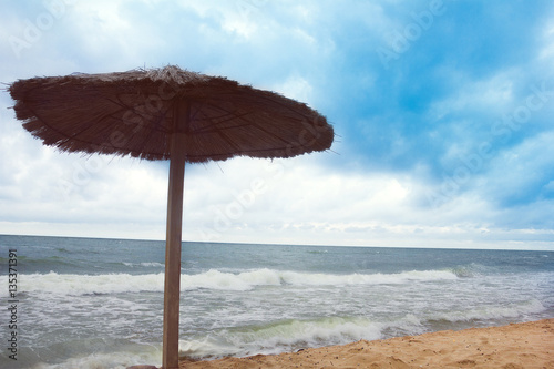 sea coast with thatched umbrella