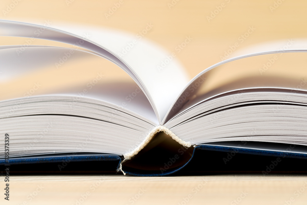 Fototapeta premium Open book on wooden table.