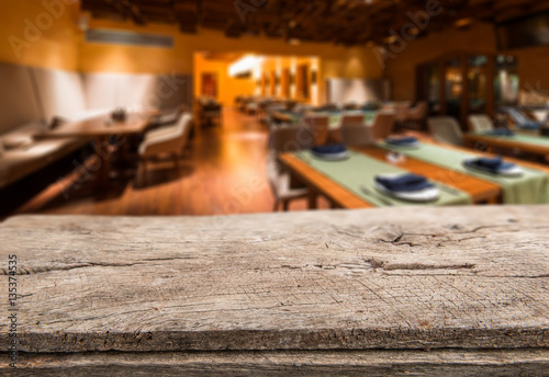 Empty table board and defocused interior of restaurant as background. Mockup for display and montage product © poplasen