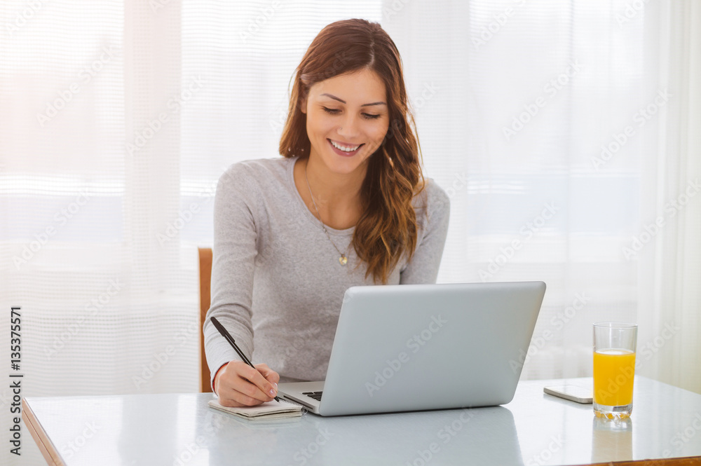 Woman freelancer female hands with pen writing on notebook at ho Woman freelancer female hands with pen writing on notebook at ho