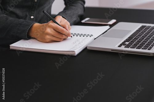 Close-up of female hands. Woman writting something and sitting a photo