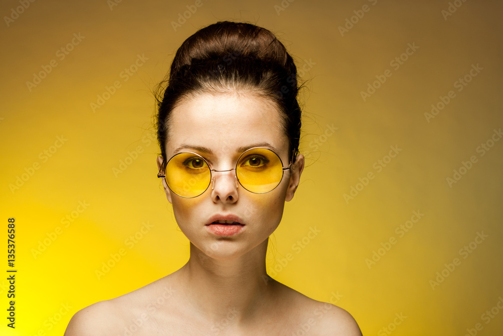 woman in yellow glasses looks at the camera woman in yellow glasses looks at the camera