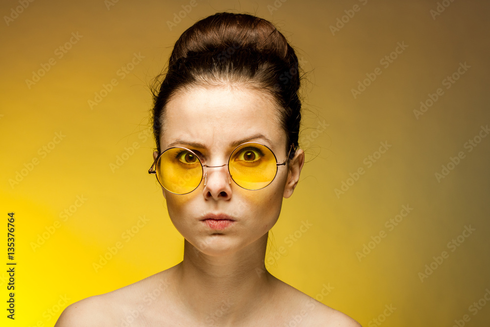 the woman in glasses frowned, the yellow background