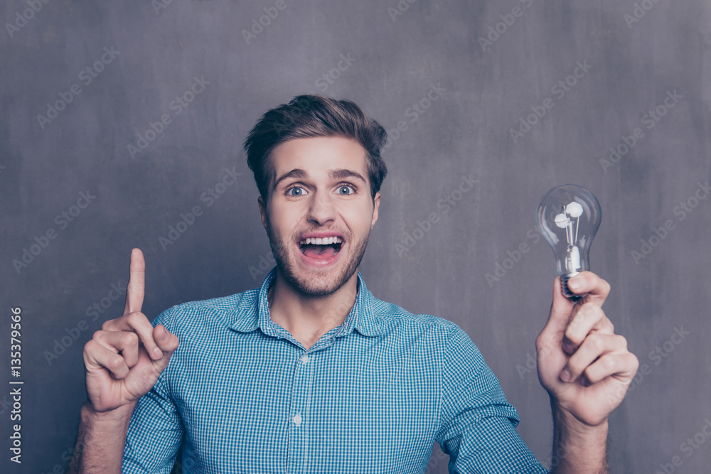 Portrait of young smart man with idea holding lamp and gesturing