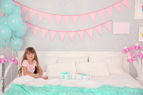 Cute birthday girl in bed w...