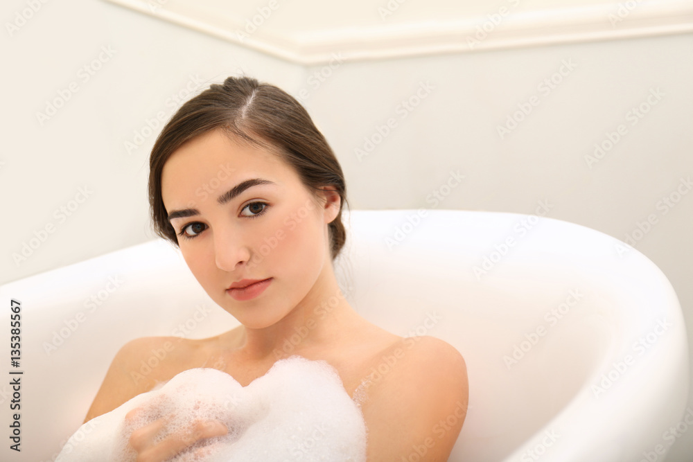 Young beautiful woman taking relaxing bath with foam, closeup Young beautiful woman taking relaxing bath with foam, closeup