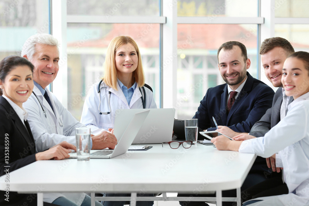 Team of doctors sitting at table in clinic Team of doctors sitting at table in clinic