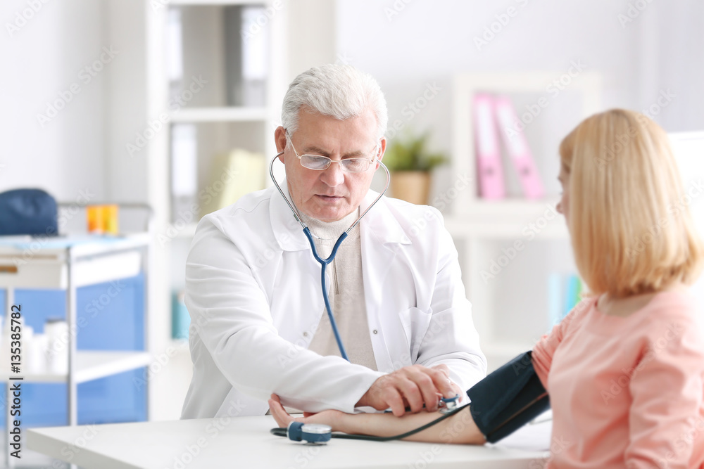 Doctor measuring blood pressure of patient Doctor measuring blood pressure of patient