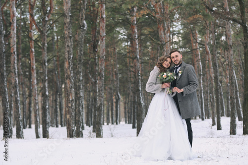 Happy wedding couple outdoors on winter day © Africa Studio