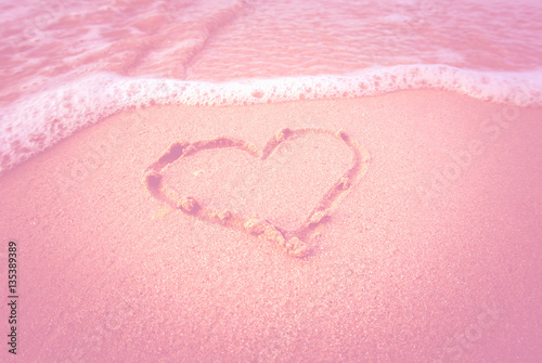 Drawn heart on beach. filtered pink style