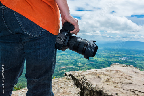 Woman with digital camera at view point on mountain. Travel life