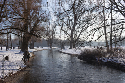 MUNICH – JANUARY 28: RIver in the park on a cold winter day. Peo
