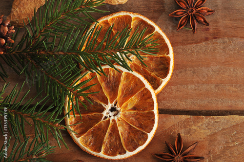 dried oranges and fir tree branch on rustic wooden background