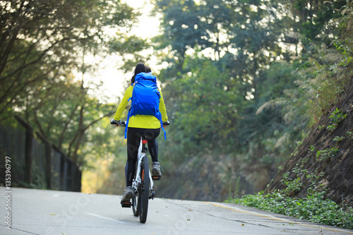 Fototapeta Naklejka Na Ścianę i Meble -  one young woman cyclist riding mountain bike on forest trail
