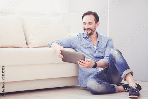 Cheerful man using tablet photo