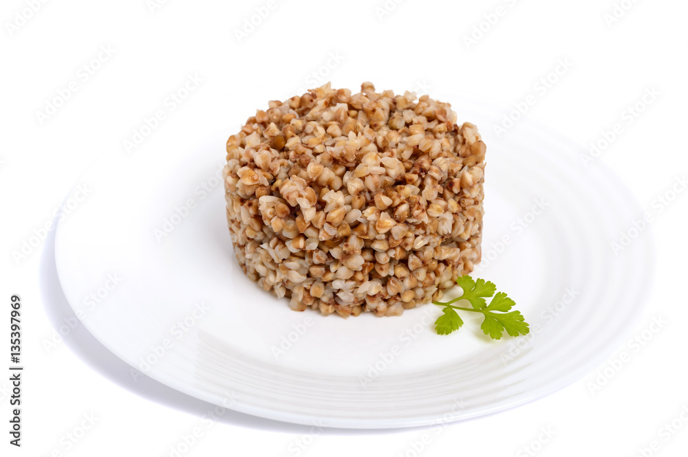 Buckwheat porridge in the form of a circle on a white plate on a white background. Dietary, vegan, Lenten dish. Isolate object. Buckwheat porridge in the form of a circle on a white plate on a white background. Dietary, vegan, Lenten dish. Isolate object.