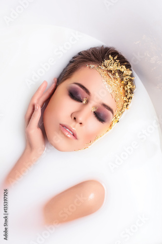 Young beautiful girl in bath spa, mask for face, care, milk bath, spa treatments