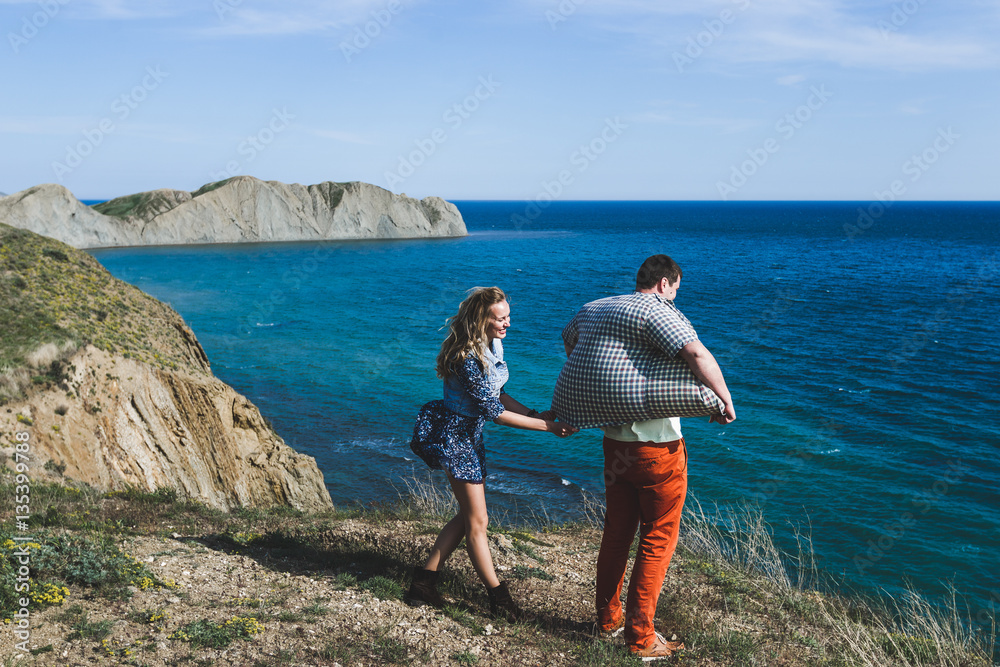Funny photo of young couple. Shirt inflated by the wind from the sea Funny photo of young couple. Shirt inflated by the wind from the sea
