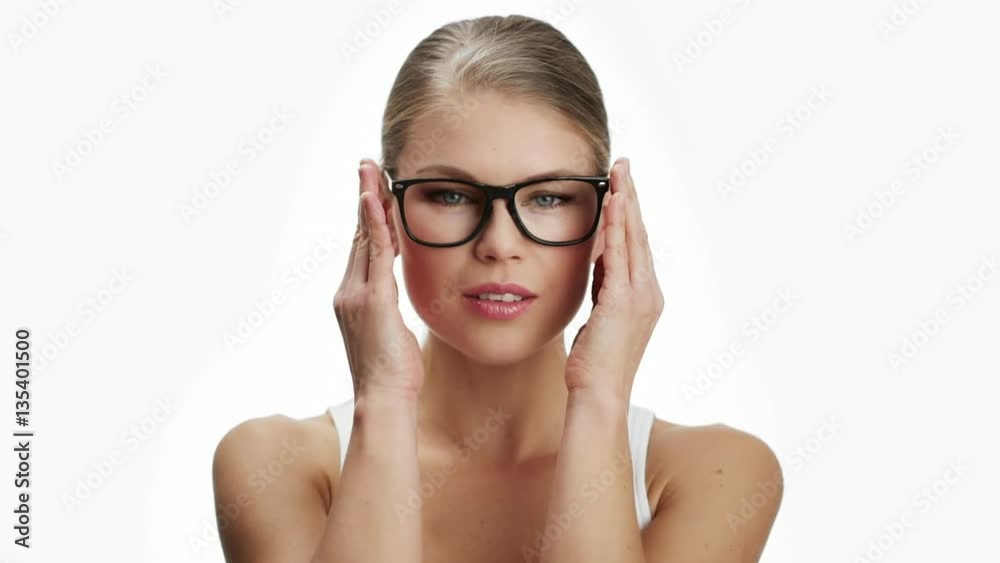 Beautiful woman putting on optical eyeglasses and smiling. Concept of vision, eye care and ophthalmology. Beautiful woman putting on optical eyeglasses and smiling. Concept of vision, eye care and ophthalmology.