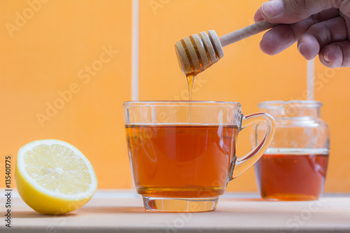 drop of honey into a glass of lemon tea