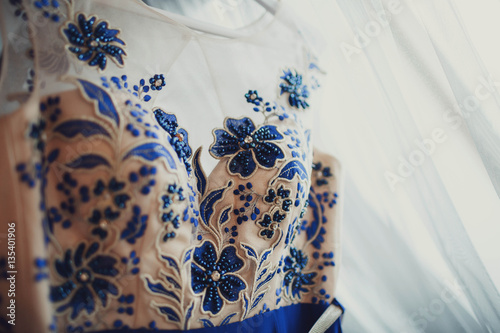 details of beautiful evening dress with blue flowers © myronovychoksana