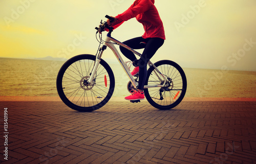 one young woman riding bike on seaside