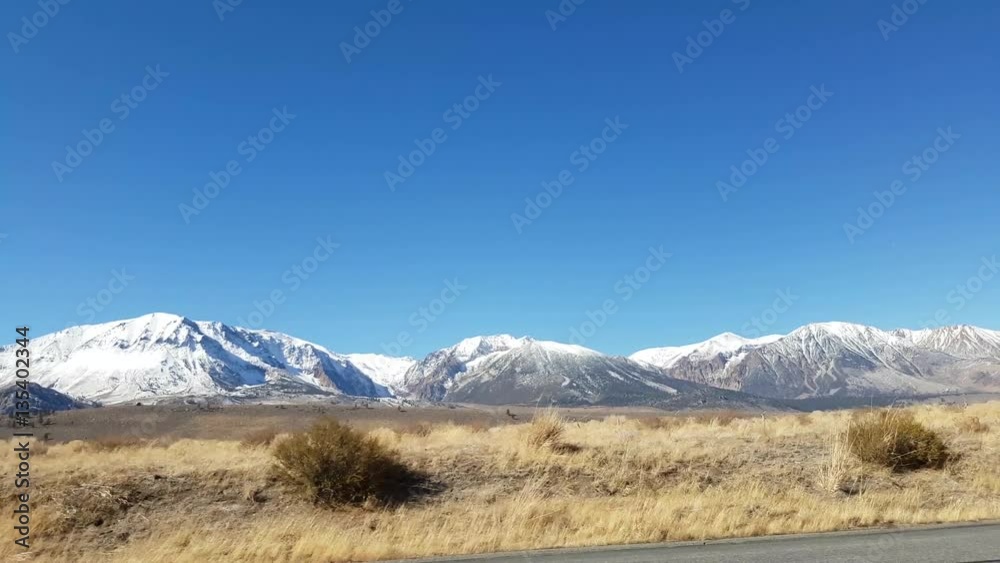 Car window view of snowy mountains on route 395, on a sunny november day, near mono lake and lee vining, in California, United states of America Car window view of snowy mountains on route 395, on a sunny november day, near mono lake and lee vining, in California, United states of America