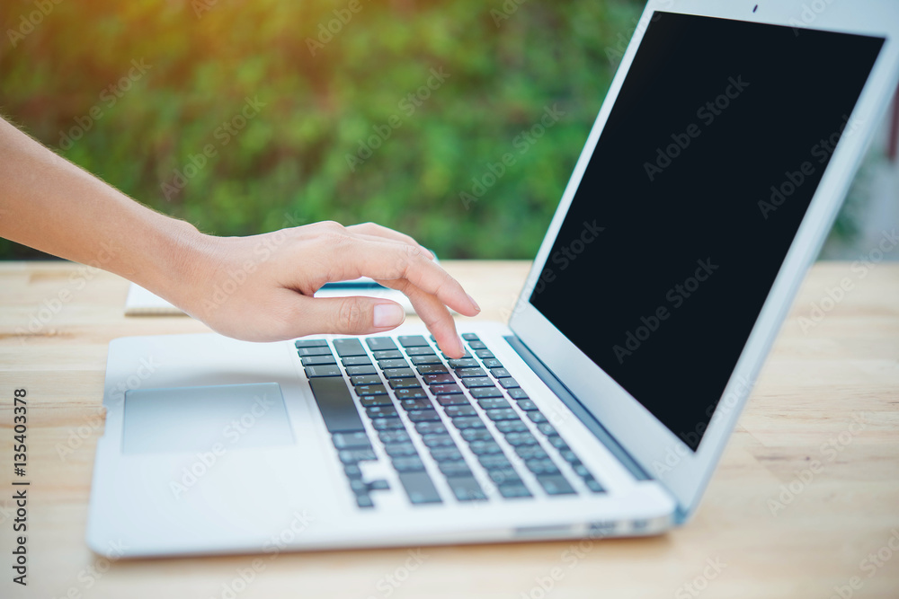 woman hands typing on laptop keyboard on wooden table woman hands typing on laptop keyboard on wooden table