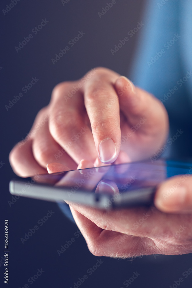 Female finger touching smart phone screen Female finger touching smart phone screen