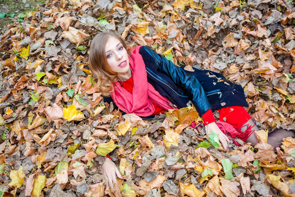 cheerful positive dreamy girl lying among the leaves in the park cheerful positive dreamy girl lying among the leaves in the park