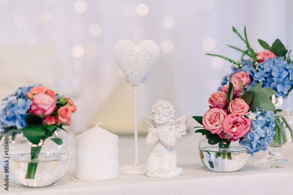 Figures of praying angel and ange stand between vases with roses Figures of praying angel and ange stand between vases with roses