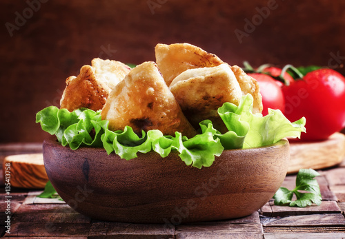 Homemade fried little pies with meat in a bowl, vintage wooden b photo